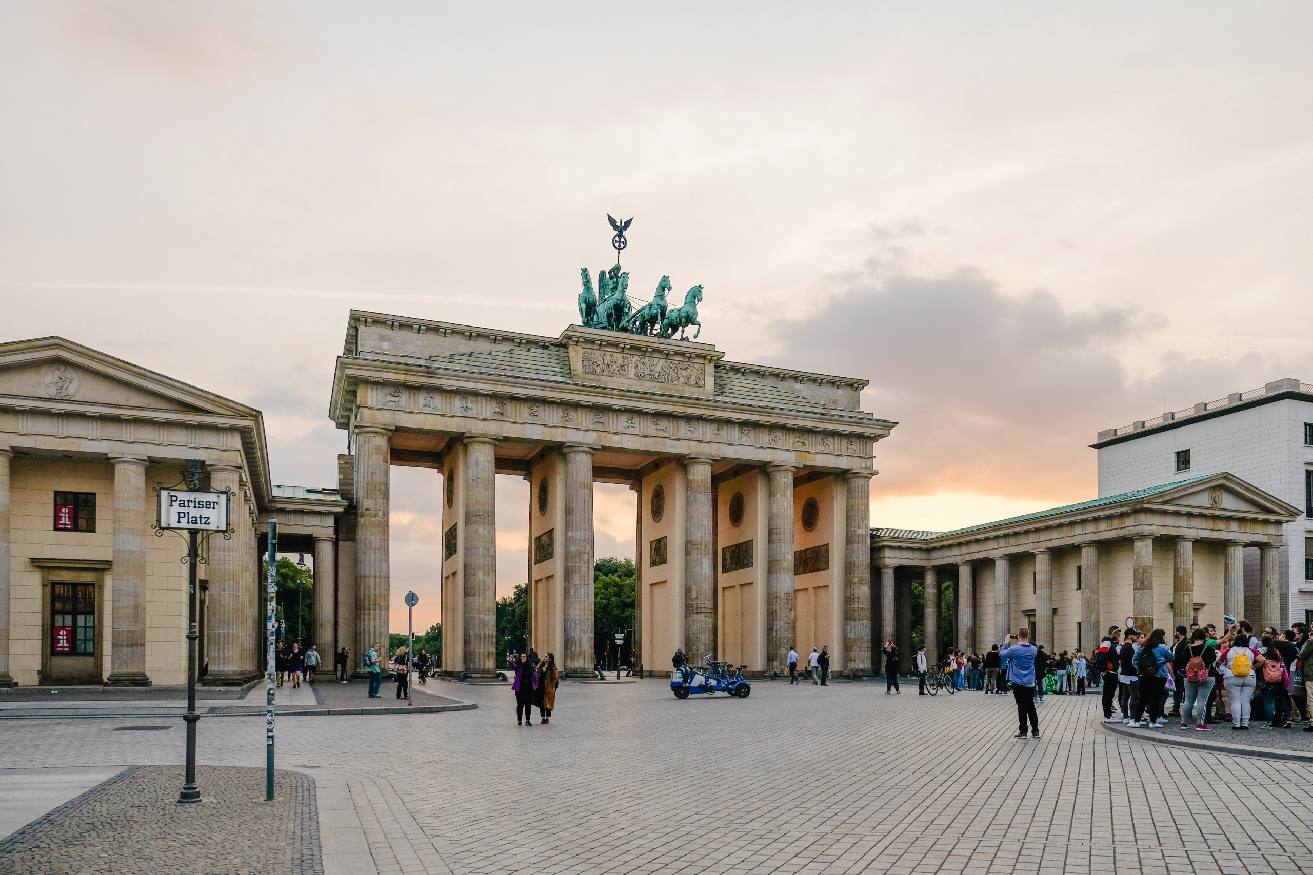 Berlin luxury real estate showcased with the iconic Brandenburg Gate at sunset.
