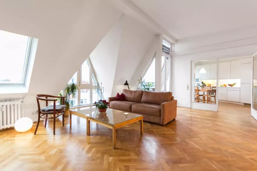 A living room with hardwood floors and a large window.